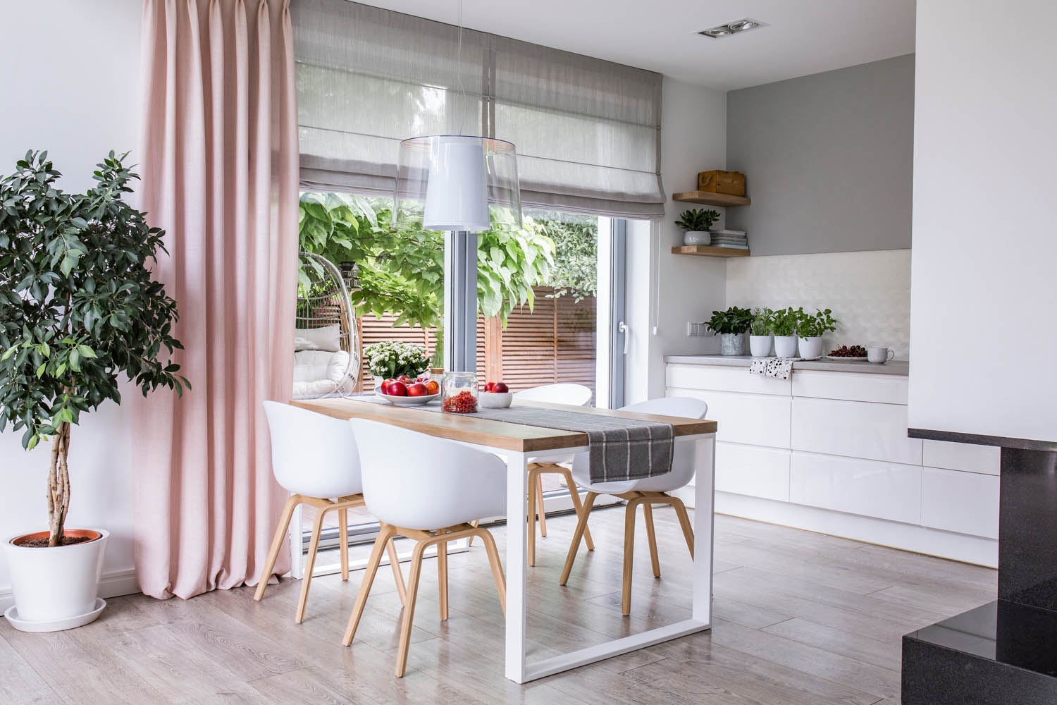 Gray roman shades and a pink curtain on big, glass windows in a